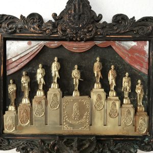 องค์หล่อในหลวงยืนอยู่บนแท่น 9 รัชกาล อยู่ในกรอบโลหะด้านบนเป็นตรามงกุฎครอบตรี  ด้านล่างมีครุฑ ด้านใต้เขียนว่า ราชวงศ์จักรี - Image 2